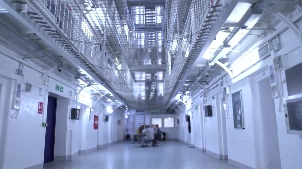 a hallway with a green exit sign on the wall