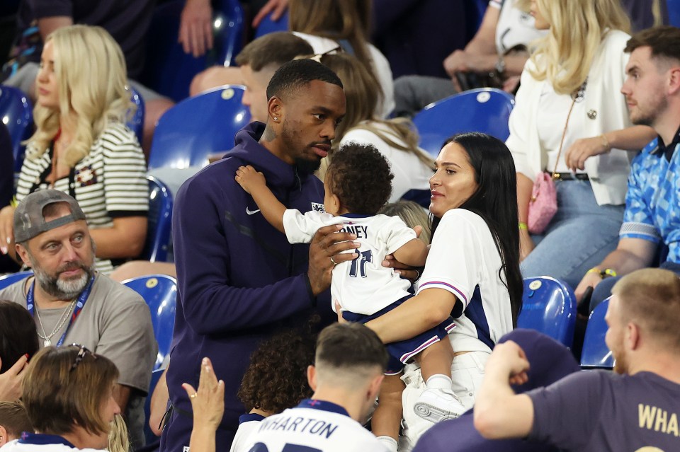 a man wearing a number 17 jersey holds a baby