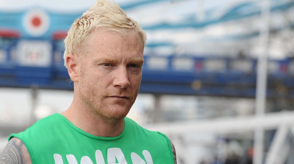 a man wearing a green tank top with the word man on it