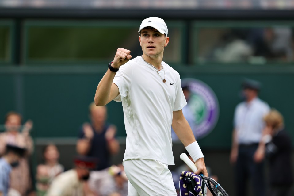 a man in a white nike shirt is holding a tennis racquet