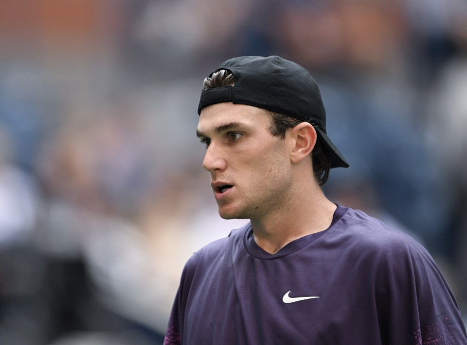 a man wearing a black hat and a purple nike shirt