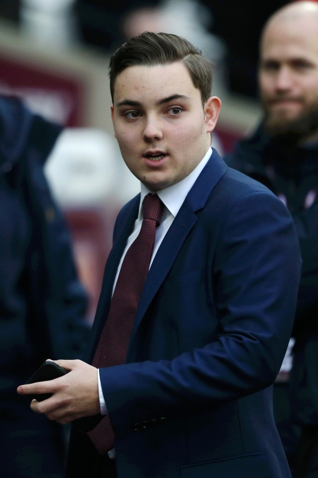 a man in a suit and tie holds a cell phone