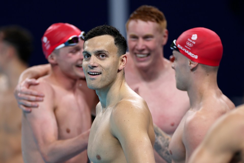 a group of swimming athletes with one wearing a red cap that says richards