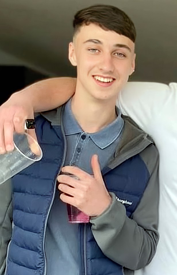 a young man wearing a berghaus vest is holding a glass of water