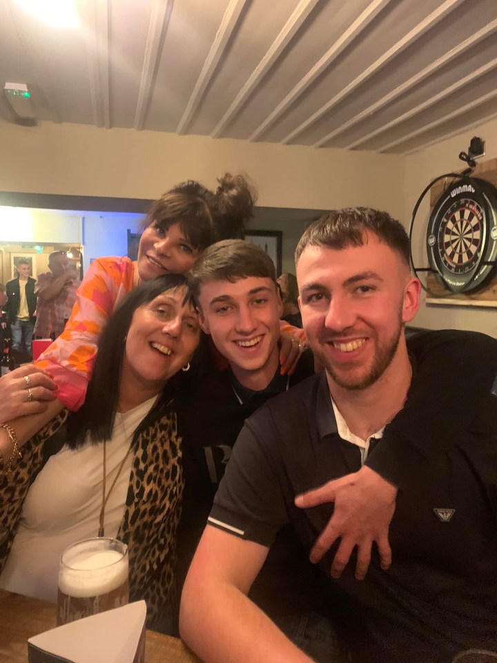 a group of people posing for a picture in front of a dart board