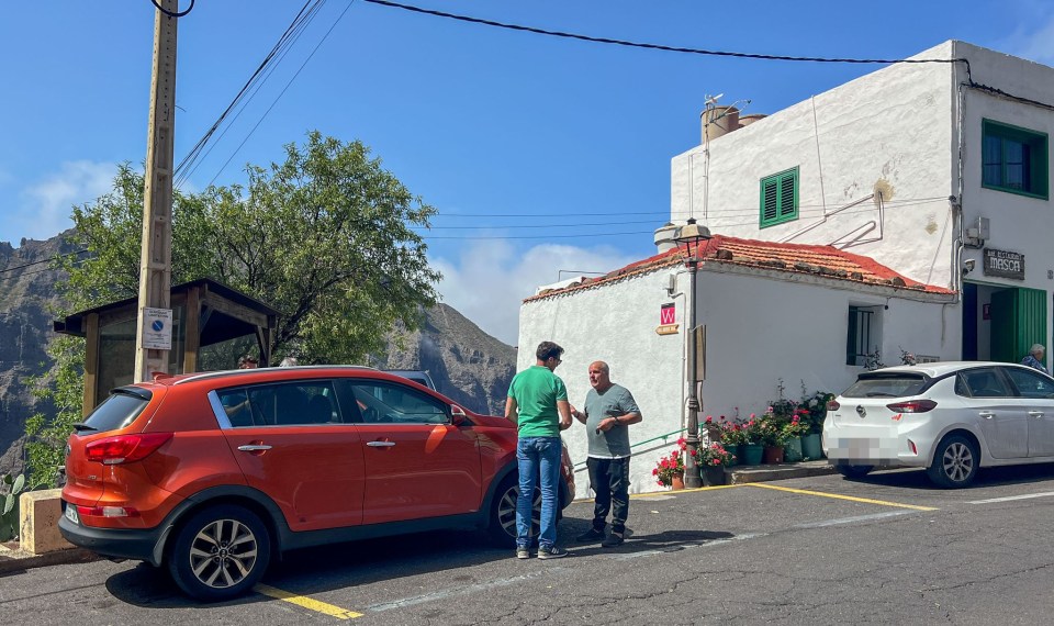 two men are standing in front of a building that has a sign that says ' ayuntamiento ' on it