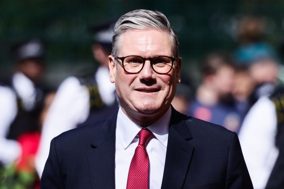 a man wearing glasses and a red tie smiles for the camera