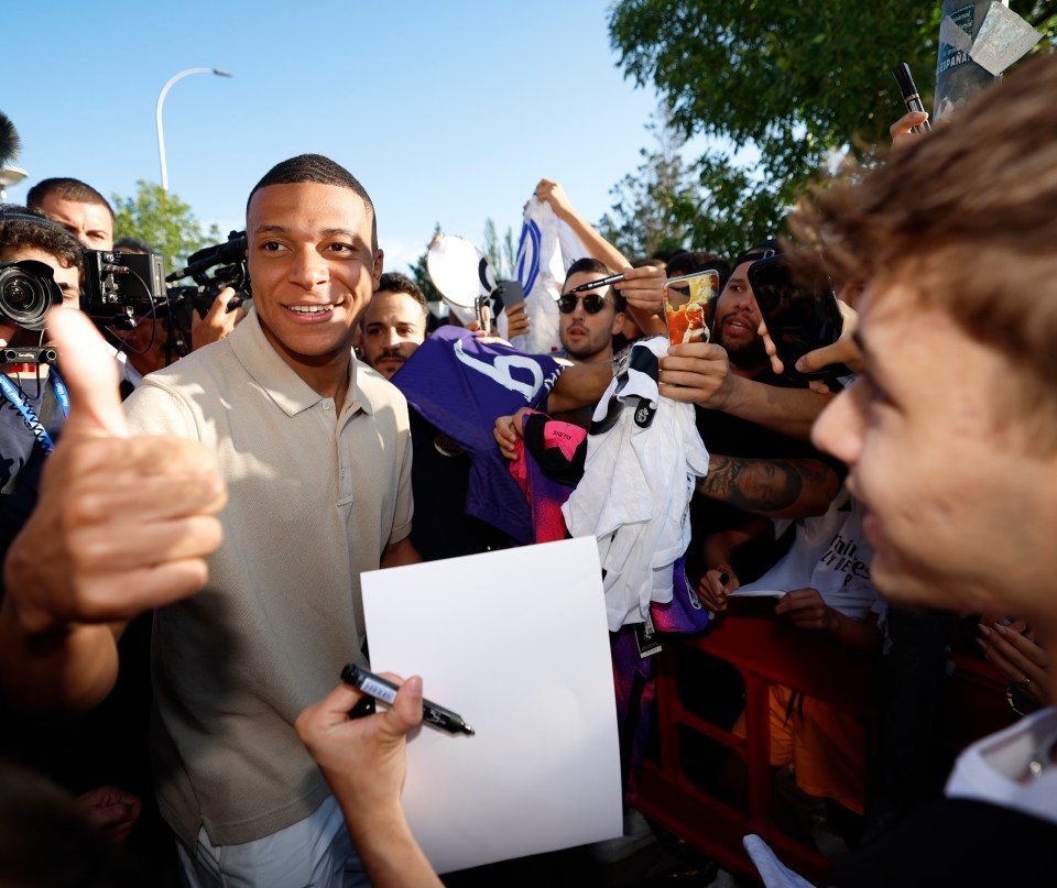 a man giving a thumbs up while holding a piece of paper with the number 8 on it