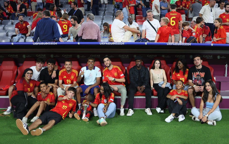 a group of people posing for a picture in a soccer stadium sponsored by qatar