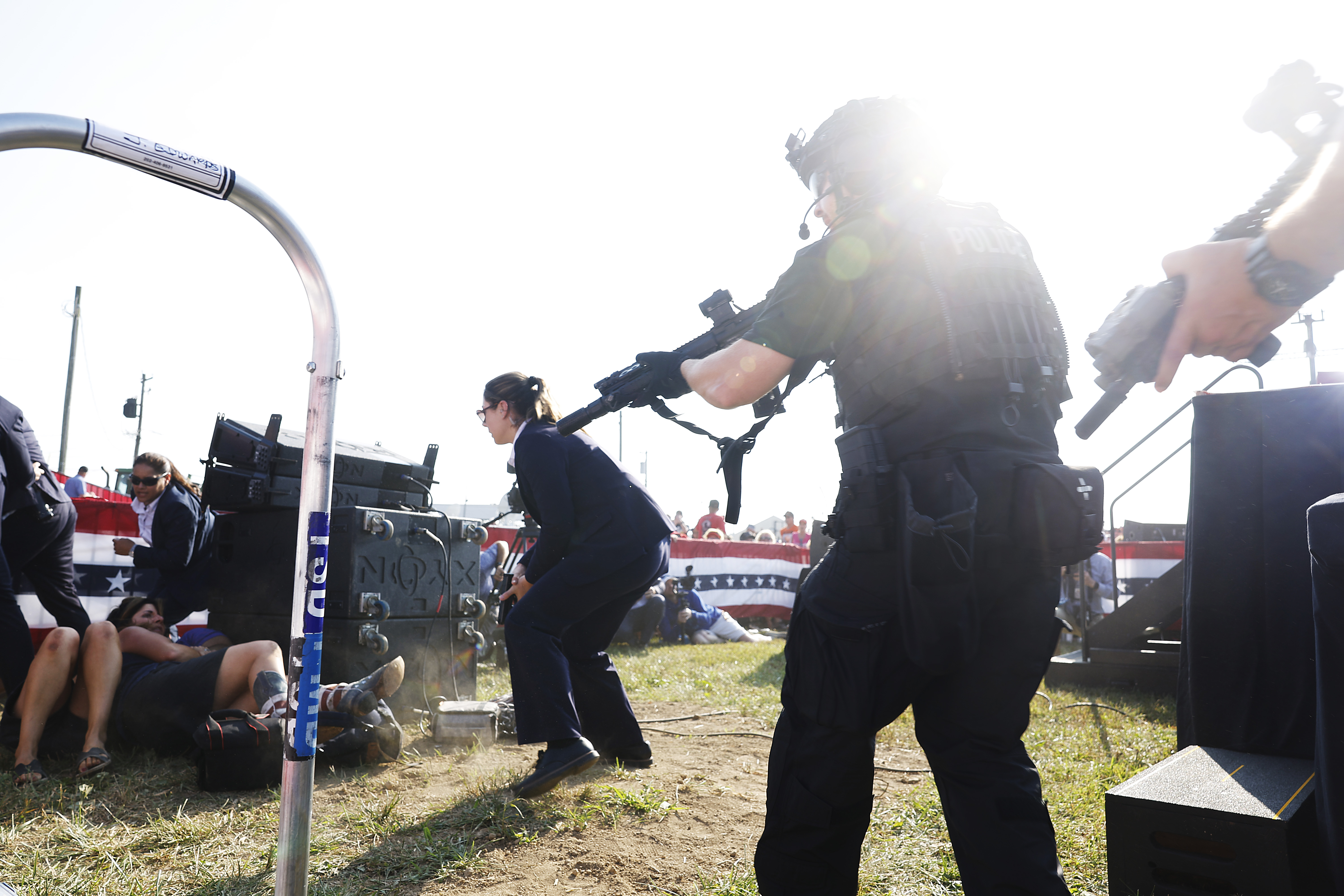 Armed security officers react as gunshots ring out at the rally