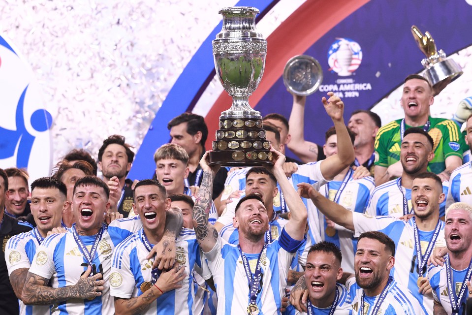 a group of soccer players celebrate with a trophy that says copa america on it