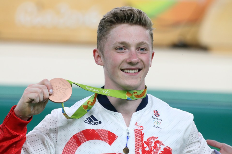 a man wearing an adidas jacket is holding a medal around his neck