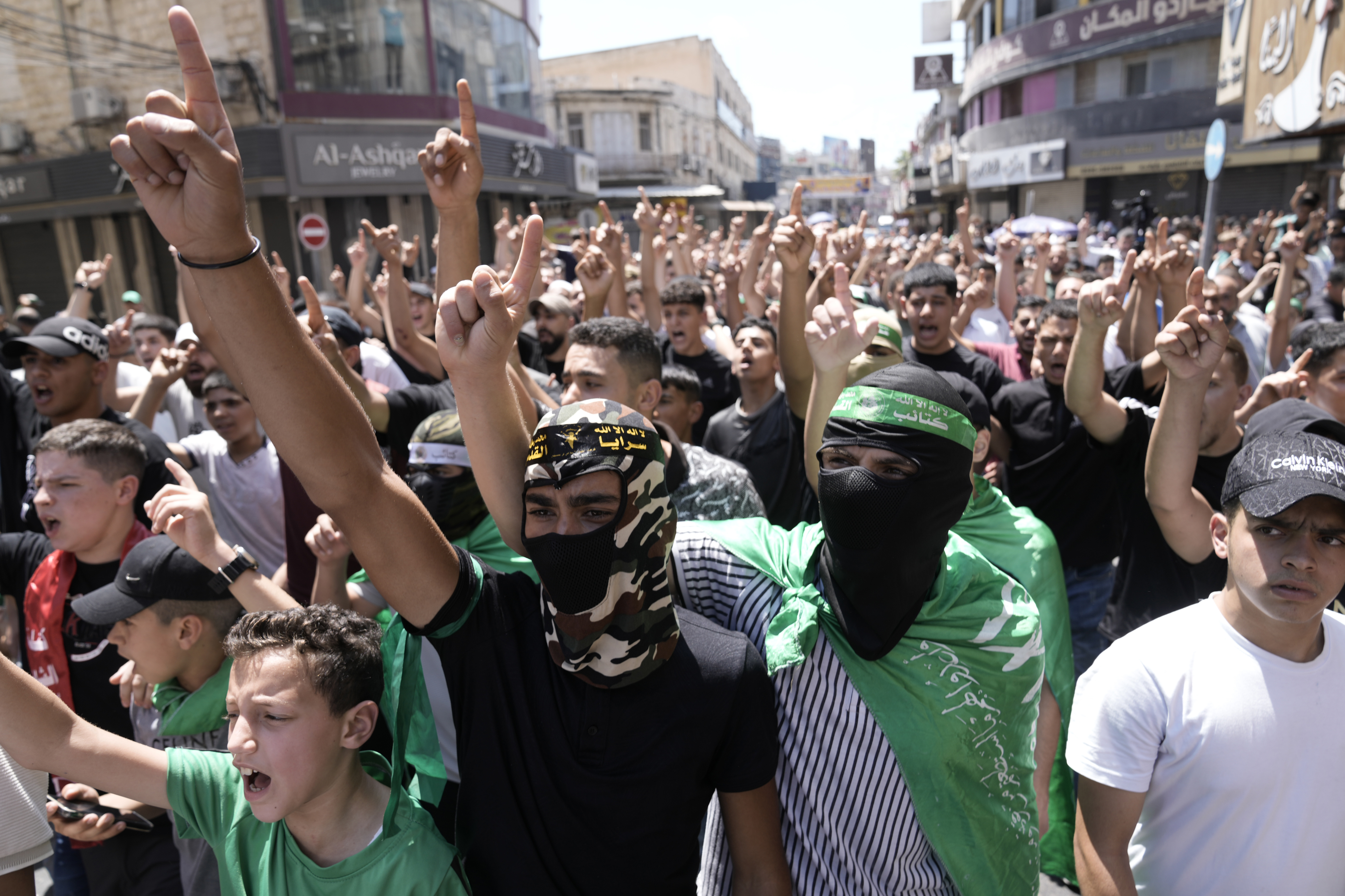 Palestinians wear Hamas militant group scarves and headbands as they protest the assassination of Haniyeh