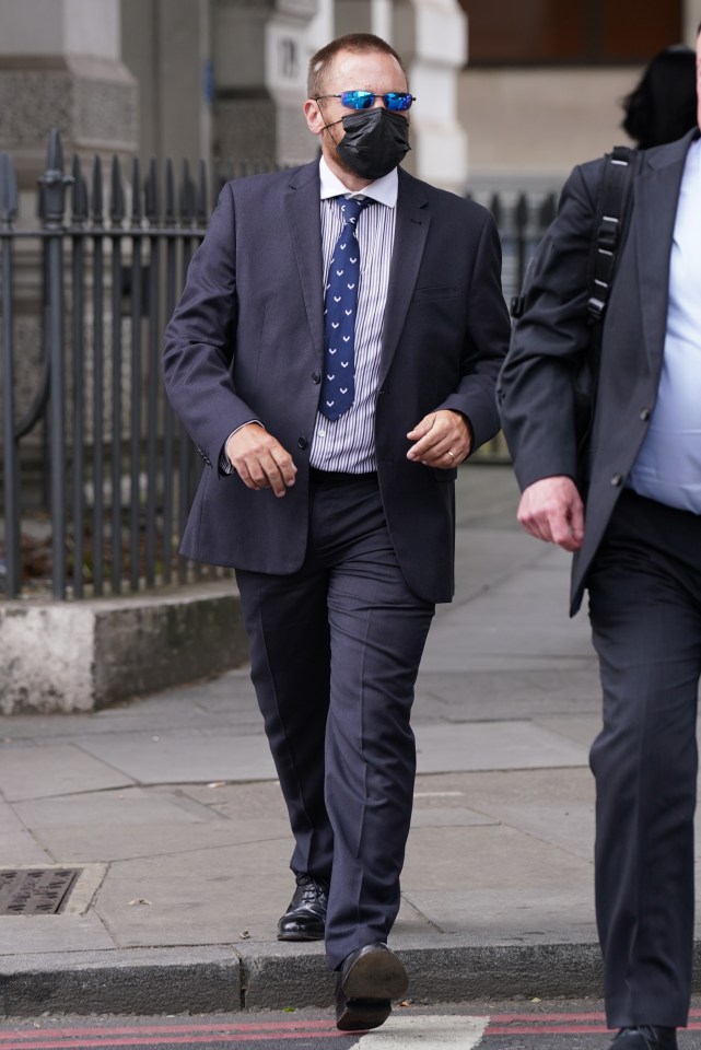 a man in a suit and tie is wearing sunglasses and a mask