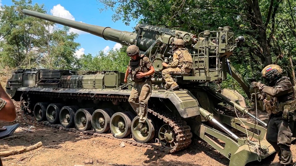 two soldiers are standing next to a tank that says ' cccp ' on it