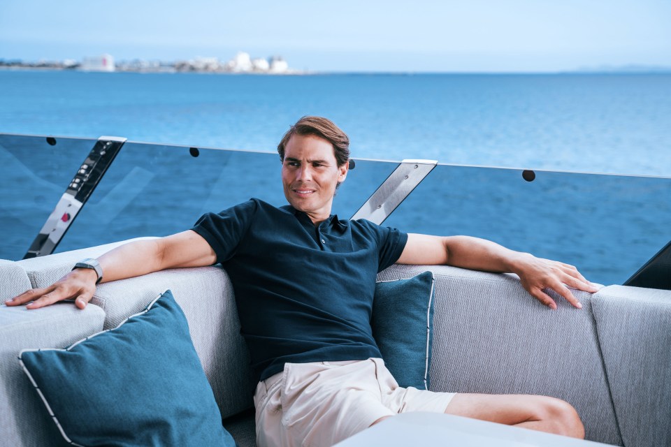 a man sits on a couch on a boat looking out over the ocean