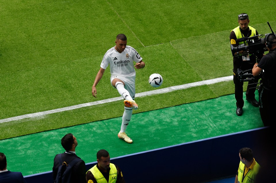 a soccer player wearing a fly emirates jersey kicking a ball