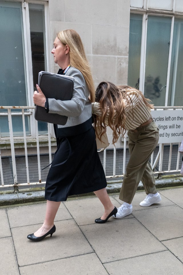 a woman pushes another woman down a sidewalk in front of a sign that says cycles left on the sidewalks will be recycled