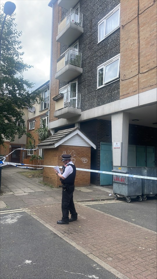 An officer makes notes at the scene in Shepherd’s Bush