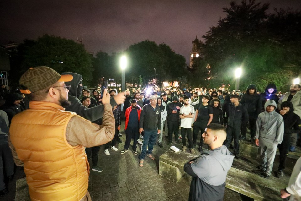 a man in a fendi hat stands in front of a crowd of people