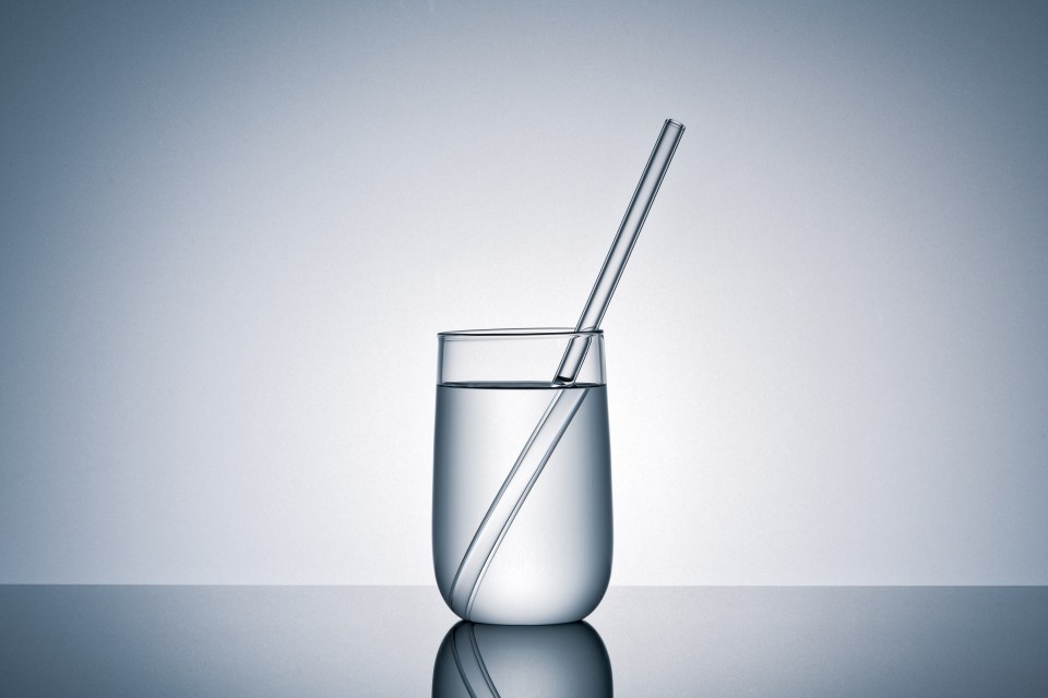 a glass of water with a straw in it