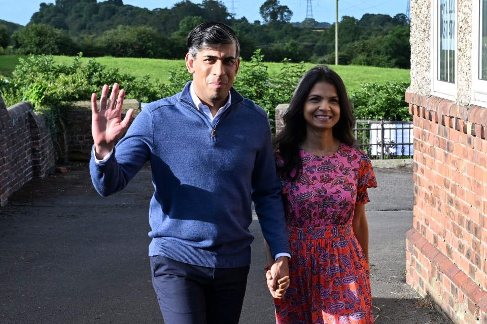 a man in a blue sweater is walking with a woman in a pink dress