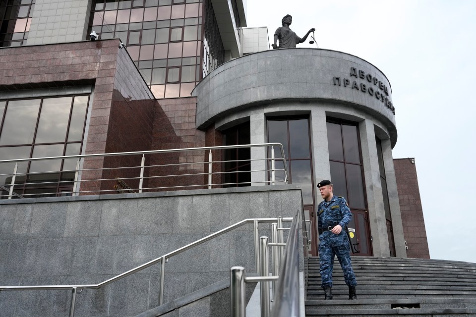 a man stands on the steps of a building that says дворец правосудия