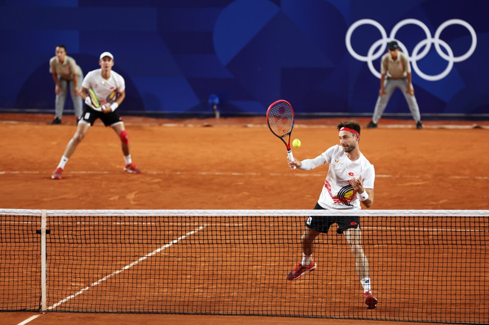 a man in a red bull shirt is playing tennis