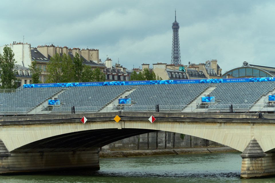 a bridge over a river with a sign that says paris olympics