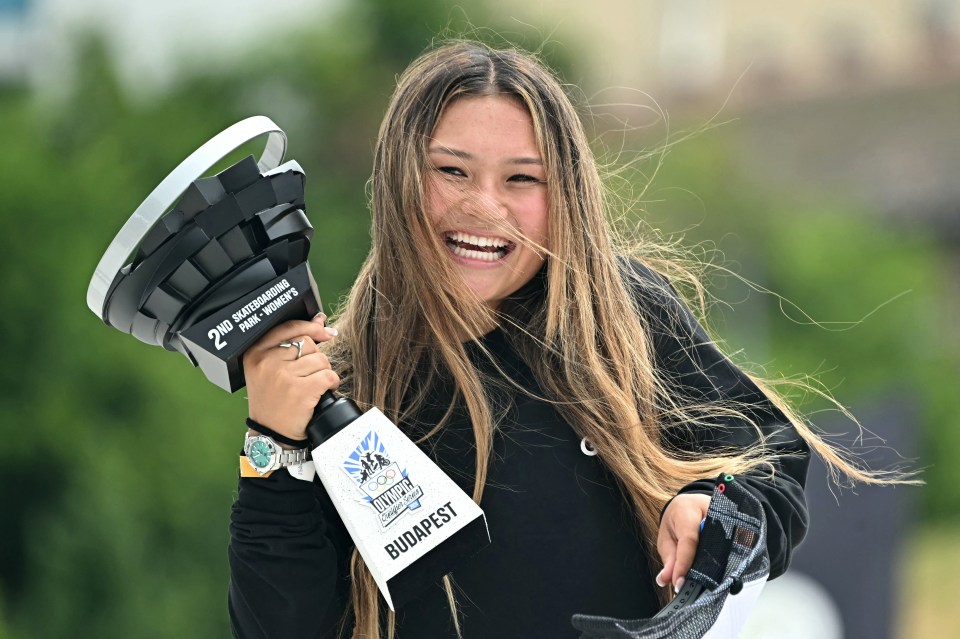 a woman holding a trophy that says ' budapest ' on it