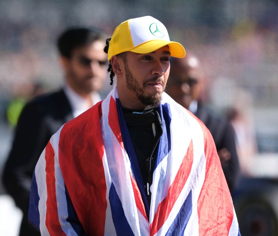 a man wearing a mercedes hat and a british flag around his neck