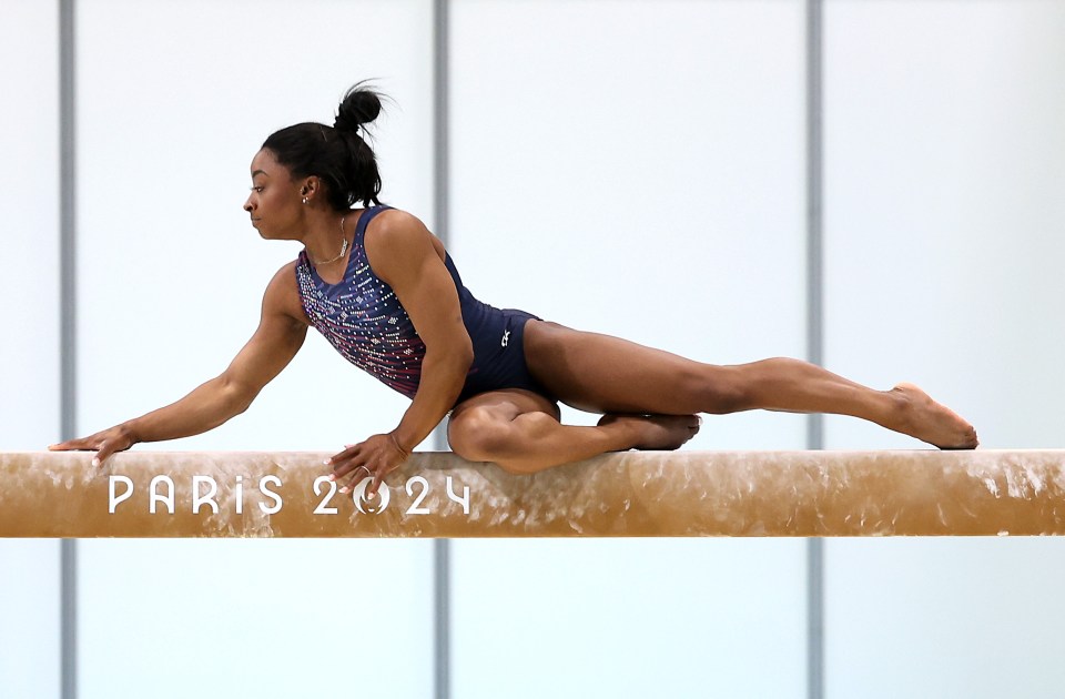 a gymnast on a balance beam that says paris 2024