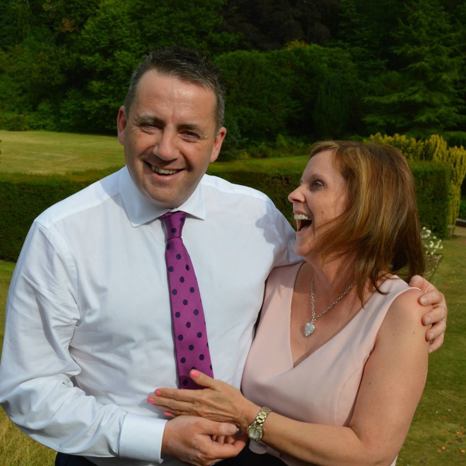 a man and woman are posing for a picture and the man is wearing a purple tie