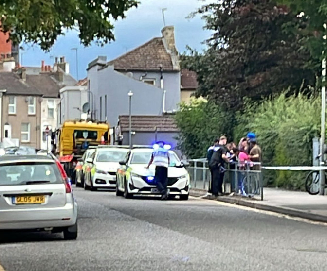 a row of police cars are parked on the side of the road