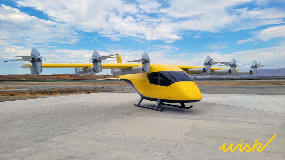 a yellow airplane is parked on a concrete runway with the word wink below it