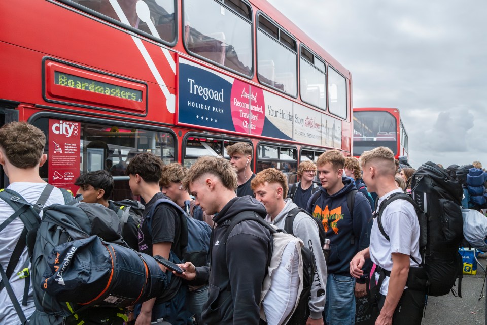 a red double decker bus has a sign on the side that says tregoad holiday park