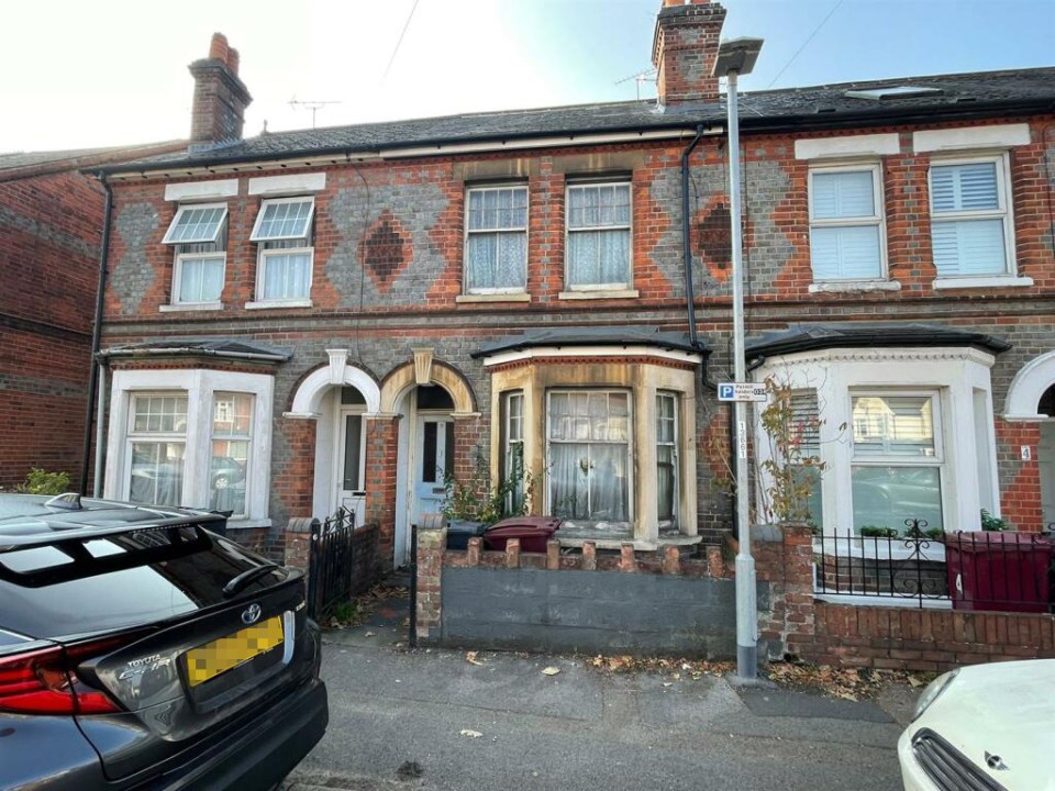 a brick house with a car parked in front of it