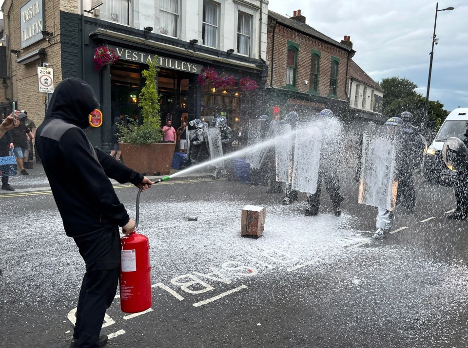 Cops were sprayed with a fire extinguisher as they battled against a volley of attacks