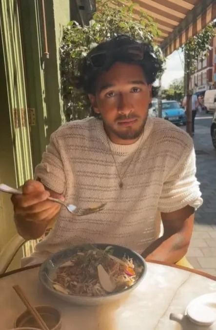 a man is sitting at a table eating a bowl of food