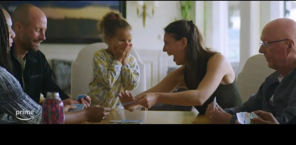 a family is playing a game of cards with an amazon prime logo in the background