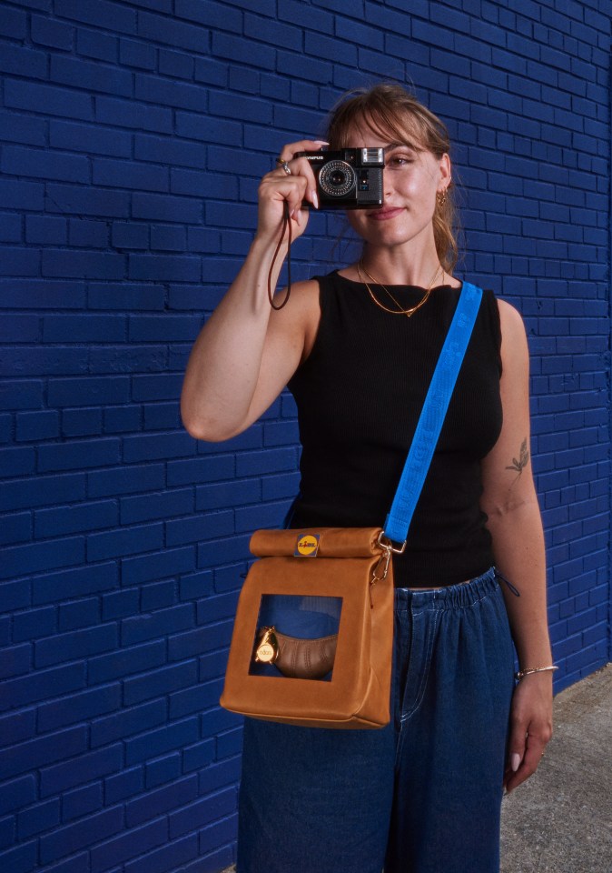 a woman taking a picture with a leica camera