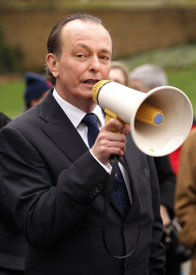 a man in a suit and tie is holding a megaphone