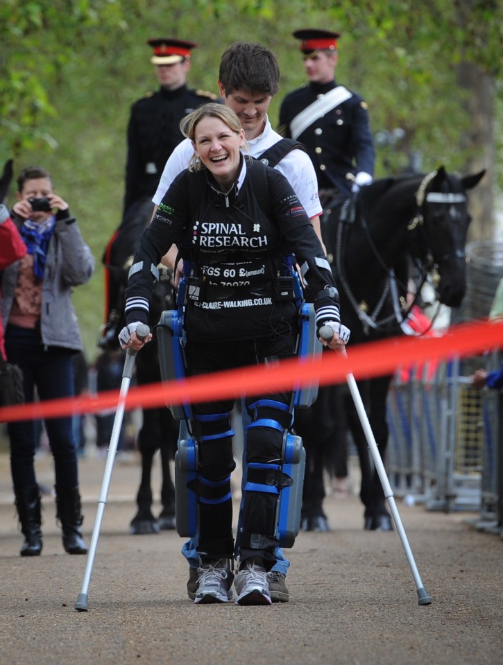 Claire crossing the finish line on The Mall in a bionic ReWalk suit