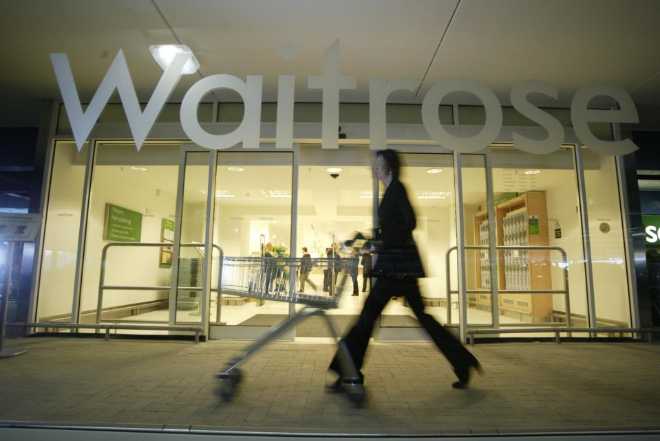 a woman pushes a shopping cart into a waitrose store