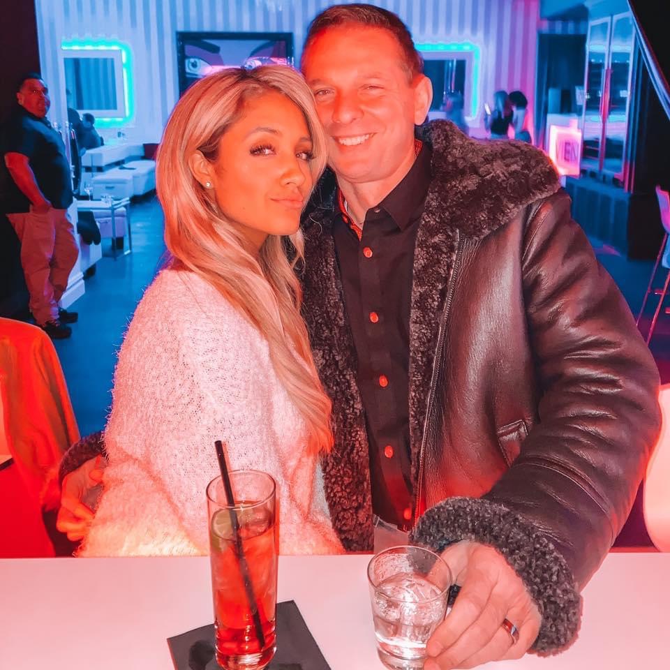 a man and a woman are posing for a picture at a bar