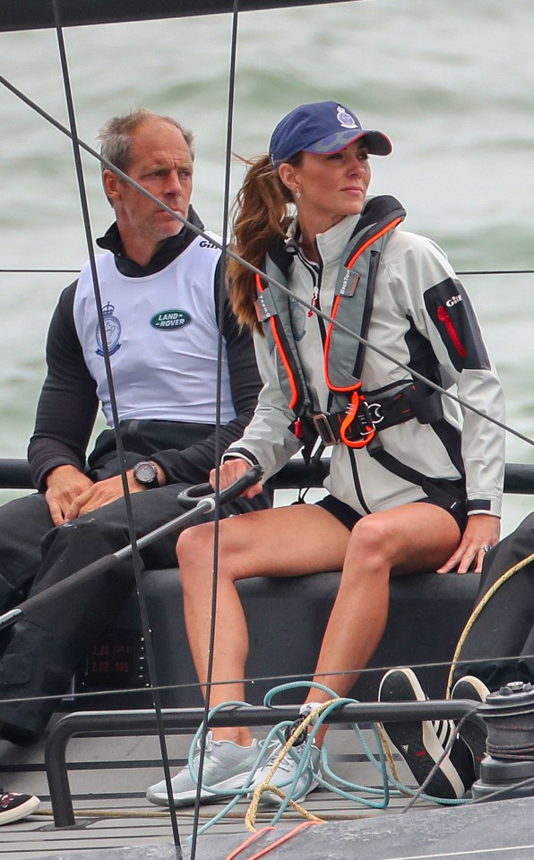 a man in a land rover shirt sits next to a woman on a boat