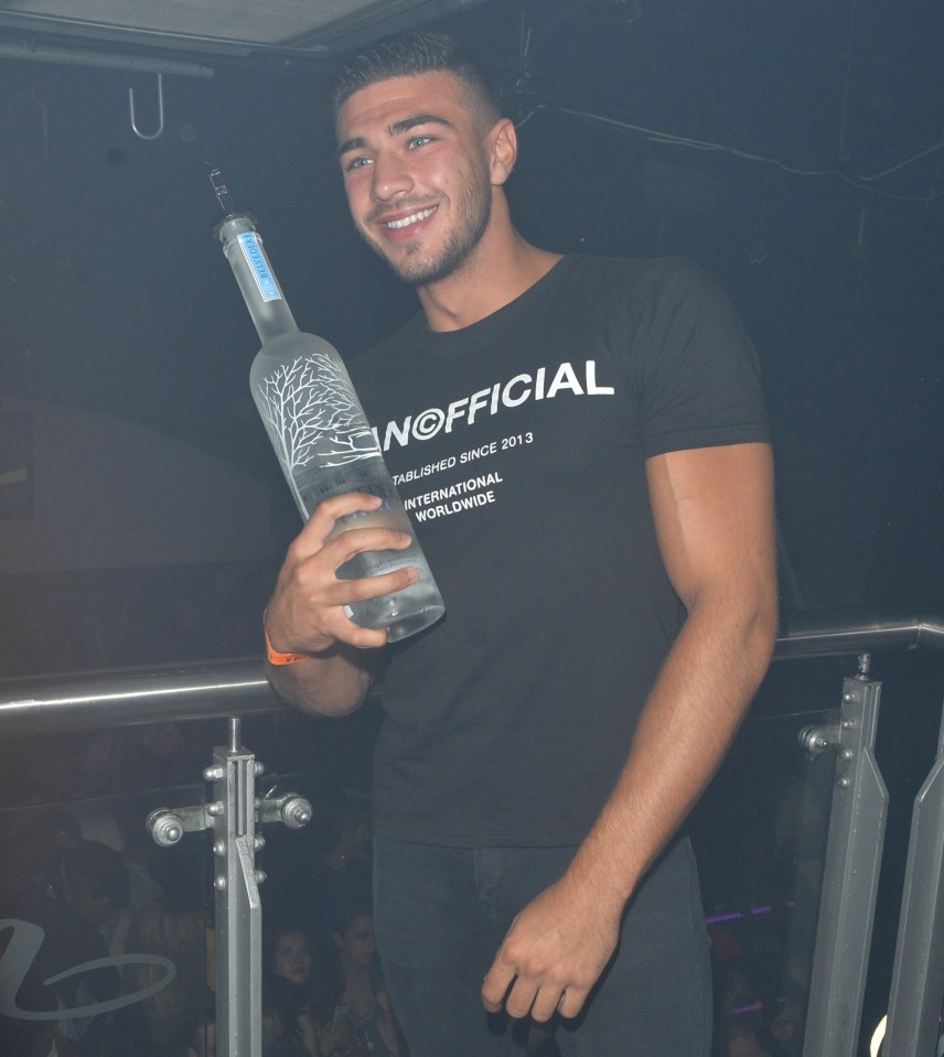 a man is holding a bottle of belvedere vodka