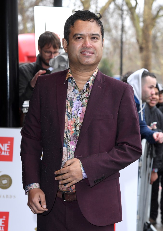 a man in a purple suit stands in front of a sign that says one for all