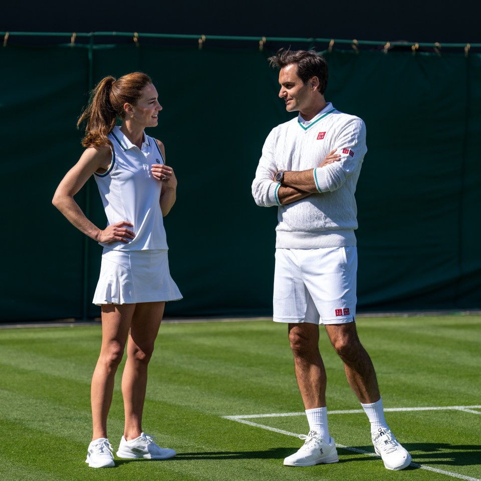 a man and a woman are standing on a tennis court with their arms crossed