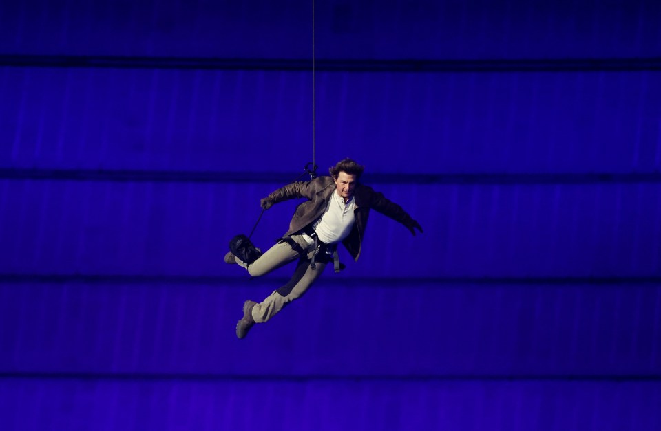 a man is hanging from a rope in the air